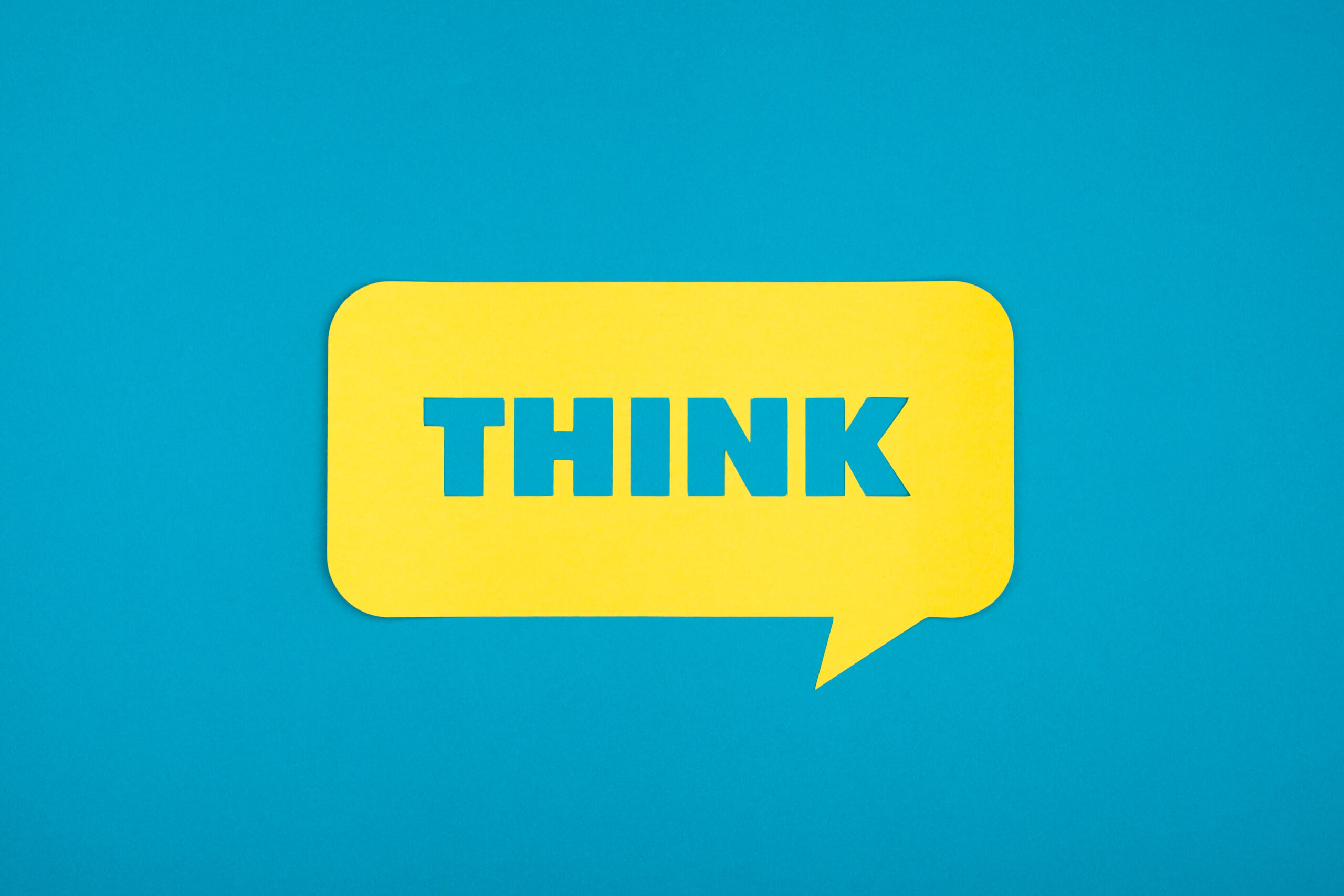 Blaue Think Schrift auf gelbem Hintergrund.
